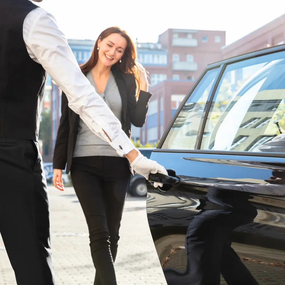 Chauffeur driver opening car door for customer